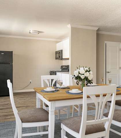 a dining room with a table and chairs and a kitchen in the background  at North Washington Apartments