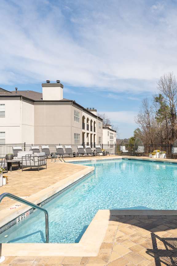 a swimming pool in front of an apartment building at sunset at WildForest Apartments, Birmingham, 35209