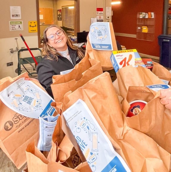 a group of people with bags of food in a warehouse