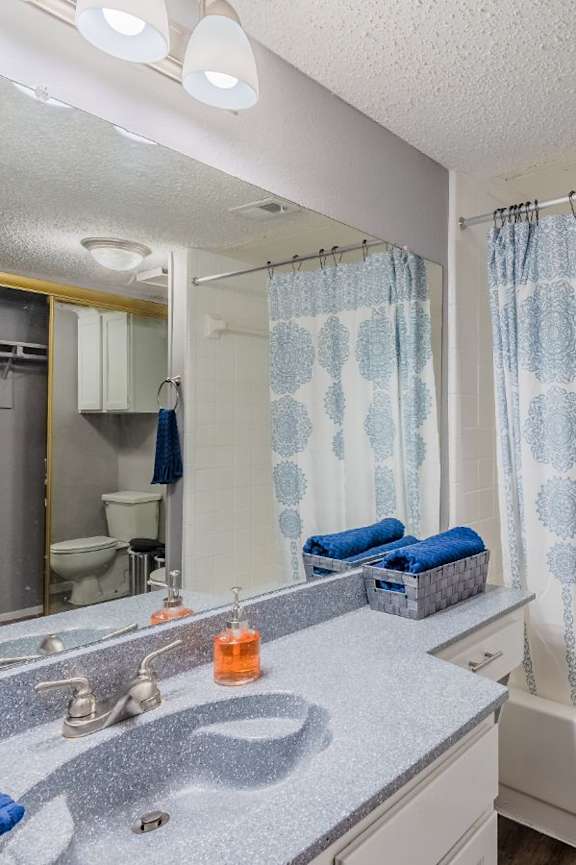 A bathroom with a shower curtain and a sink.