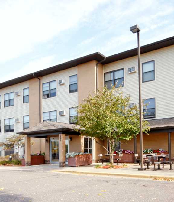 Apartment building with a parking lot in front.