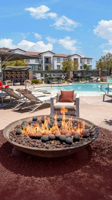 A living room with a yellow chair and a white sofa. at Miro at the Parc Apartments, Henderson , NV, 89074