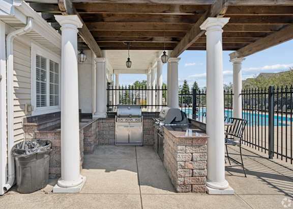 A patio with a pool in the background.