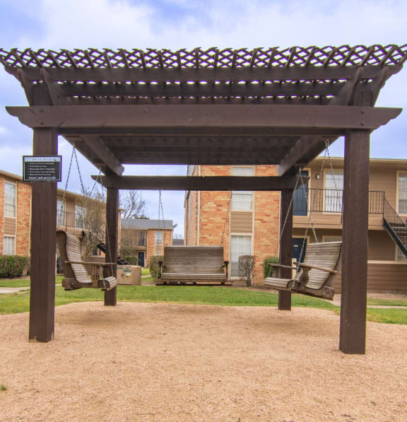 a pergola in front of an apartment building