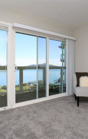 a living room with a view of a lake and a chair at The Pier at Sausalito, Sausalito, 91360