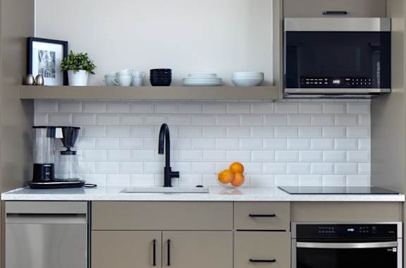 a modern kitchen with stainless steel appliances and white cabinets