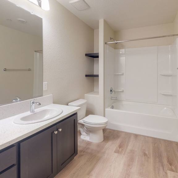 A bathroom with a sink, toilet, and shower. at Heritage Landing Apartments, Chico, California