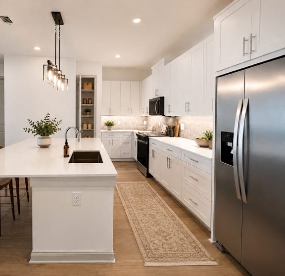 A modern kitchen with a white island and stainless steel appliances.