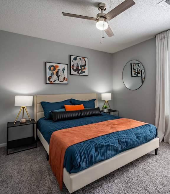 A bedroom with a bed, nightstand, and window.