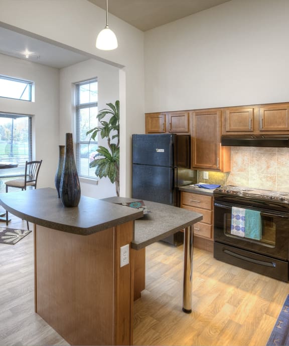 an open kitchen and living room with a view of a balcony and a living room