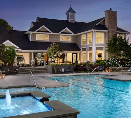 a swimming pool in front of a large house at night at AVE Malvern, Malvern, 19355