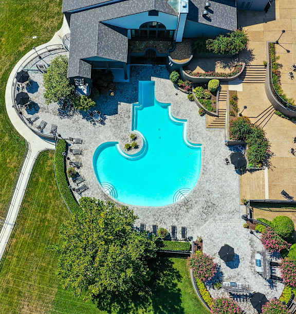 An overhead view of a rounded edge pool and clubhouse