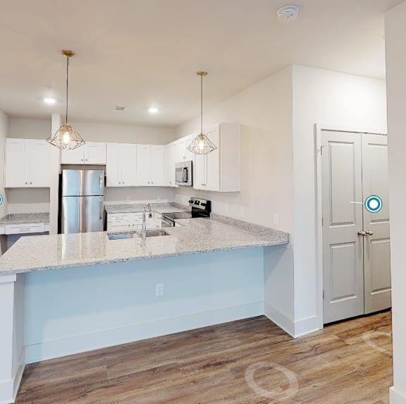 a kitchen with white cabinets and a blue counter top at Midtown Row, Montgomery