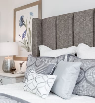 A bedroom with a bed, nightstand, and lamp.