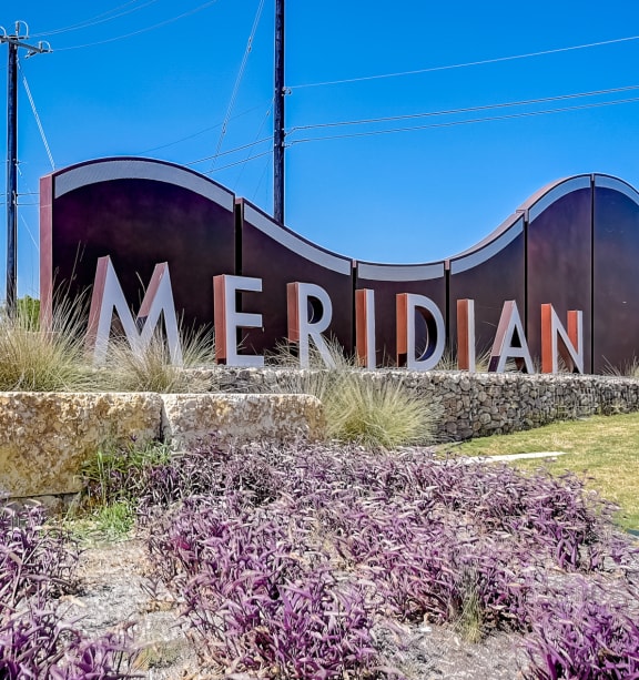a sign that says meridian with purple flowers in front of it at Beacon at Meridian, Texas, 78245
