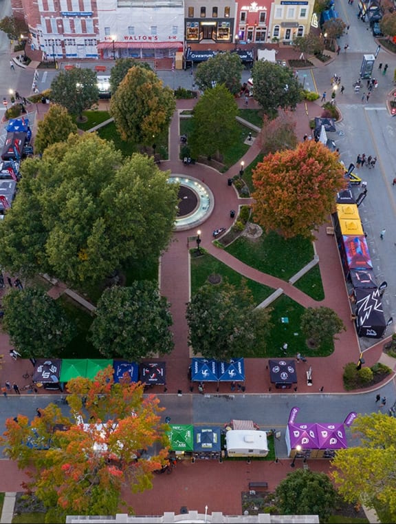 an aerial view of a city street with cars and trees
