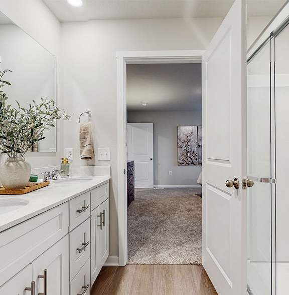 A white bathroom with a white sink and a white door.