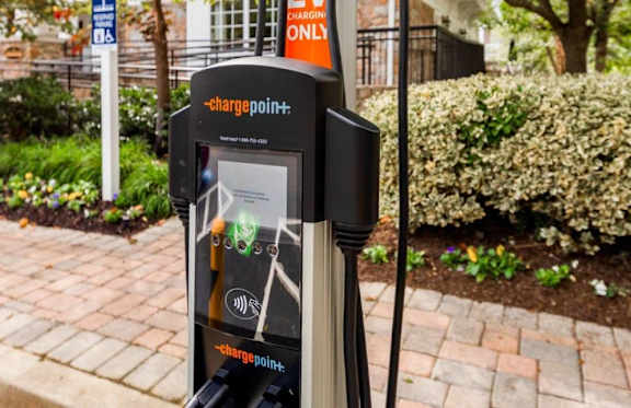 A ChargePoint electric vehicle charging station sits on a sidewalk.