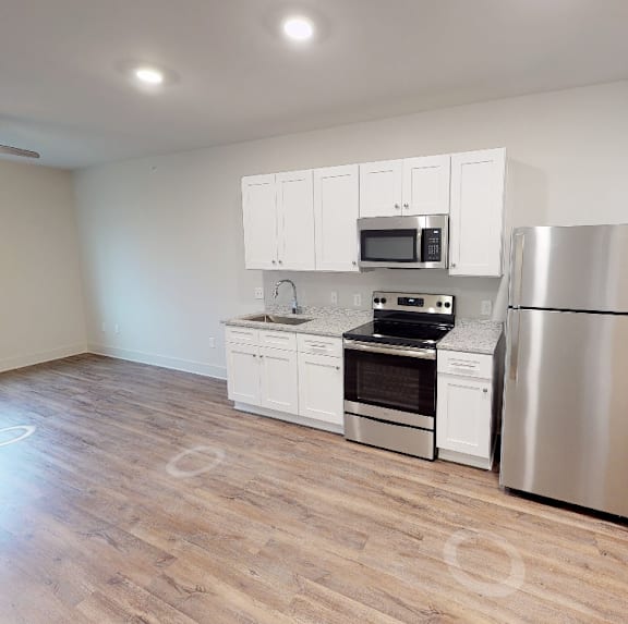 a kitchen with white cabinets and a stainless steel refrigerator at Midtown Row, Alabama, 36106