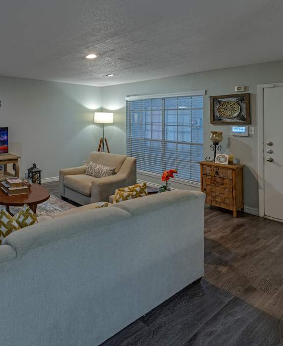 A living room with a white couch and a wooden coffee table.