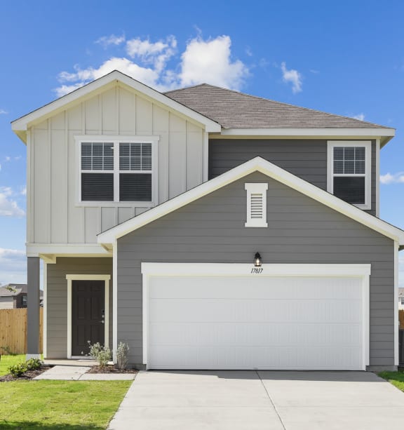 a home with a gray siding and a white garage door