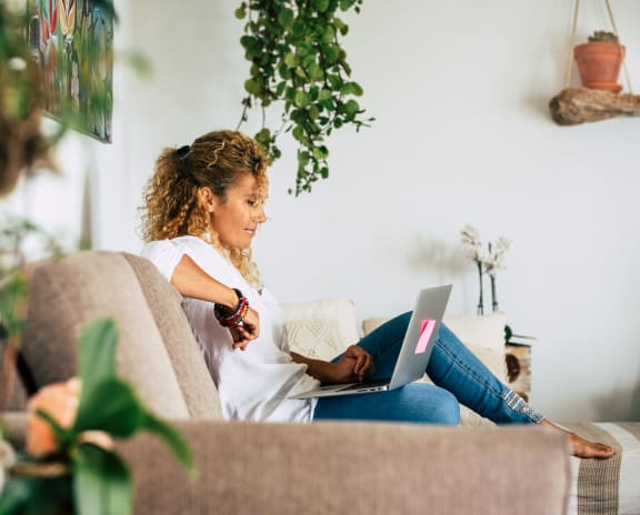 a woman sitting on a couch with a laptop at Chesapeake Ridge, Maryland
