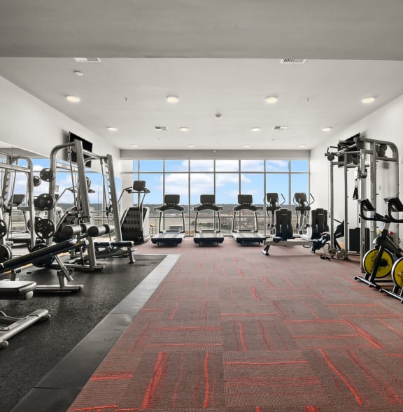 a gym filled with cardio equipment and windows