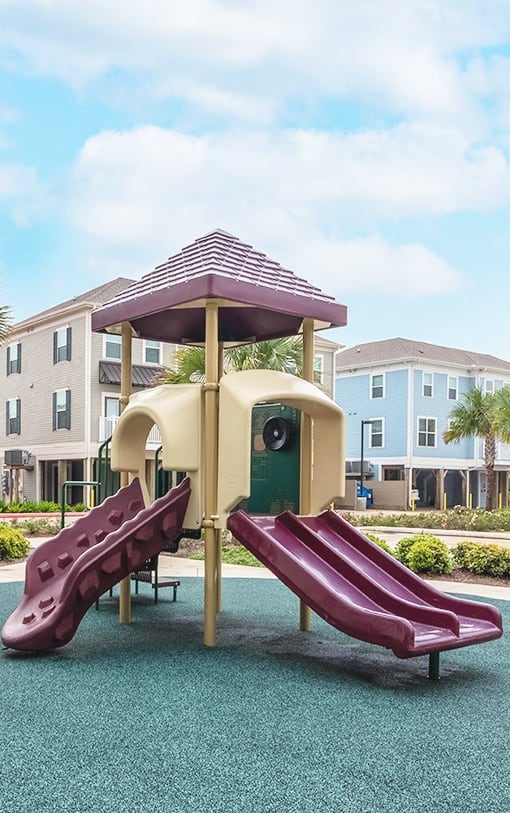 a red and beige playground at Villas on the Strand apartments in Galveston, TX