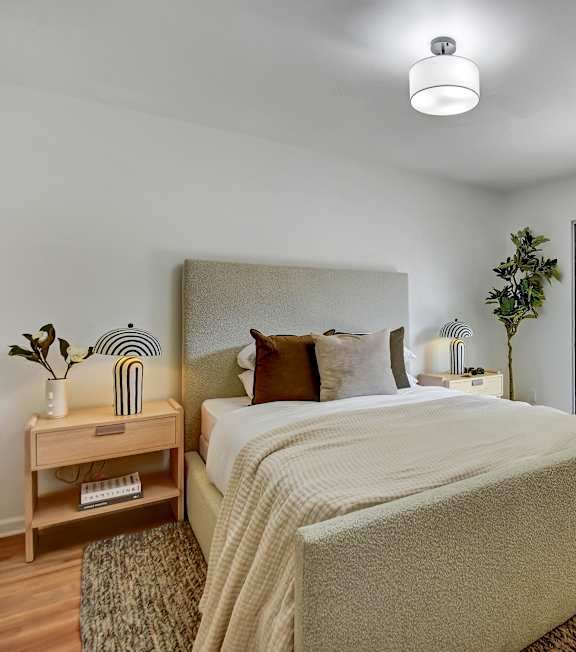 A bedroom with a large bed and a sliding glass door.