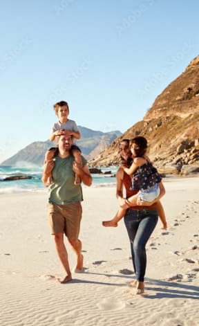 a young family walking on the beach with a child