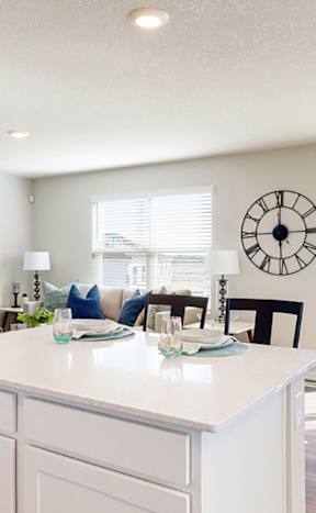 A kitchen with a large island and a clock on the wall.