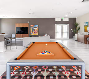 a large living room with a pool table in the middle of it