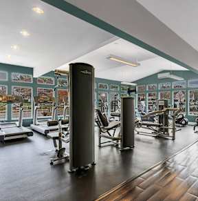 A gym with treadmills, weights and exercise equipment.