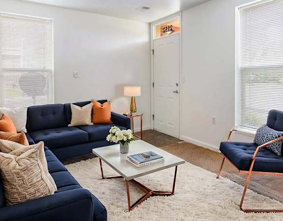 A living room with a blue sofa, a chair, and a coffee table.