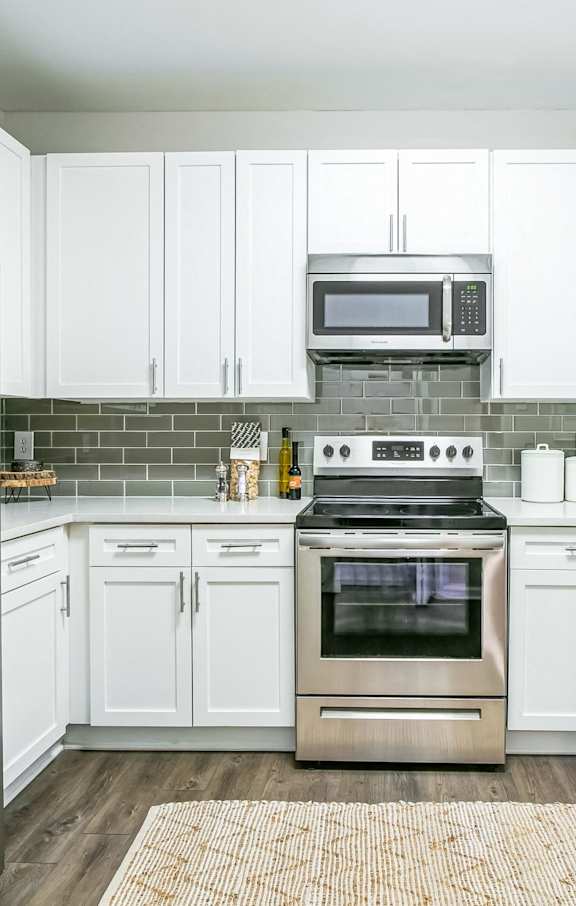 A kitchen with white cabinets and a stainless steel refrigerator at The Atlantic Buckhead Apartments, Atlanta, GA, 30305