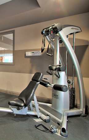 A gym with a mirror, treadmill, and exercise bike.