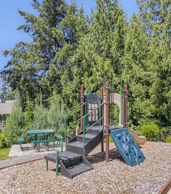 A playground with a slide and a green slide.