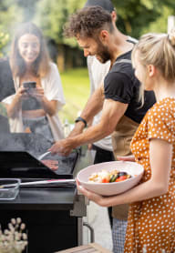 a man and a woman grilling food on a grill