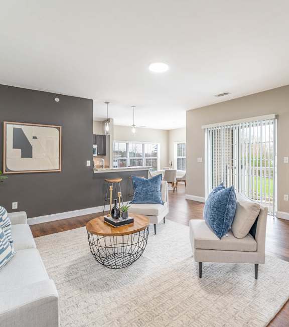 A living room with a grey couch, a white chair, and a coffee table.
