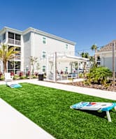 two cornhole boards on a strip of green grass