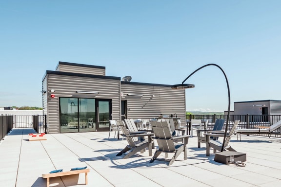 the patio on the roof of the building has tables and chairs