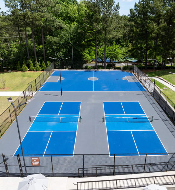 an aerial view of a tennis court with a fence around it
