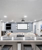 a movie theatre style room with a large tv and chairs 