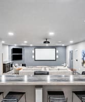a movie theatre style room with a large tv and chairs 