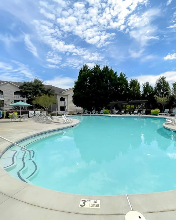 A large swimming pool with a white fence around it.