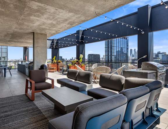 A rooftop patio with a view of the city skyline. at The Mason Apartments, Illinois, 60607