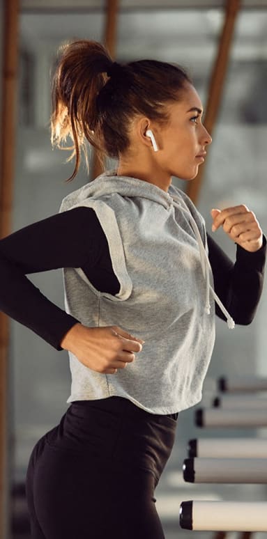 a woman running on a treadmill at a gym
