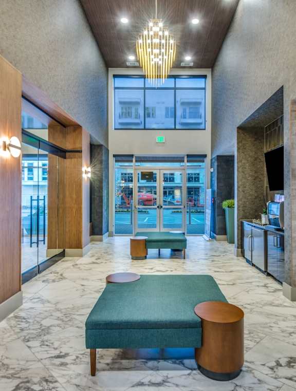 A large room with a marble floor and a green bench.