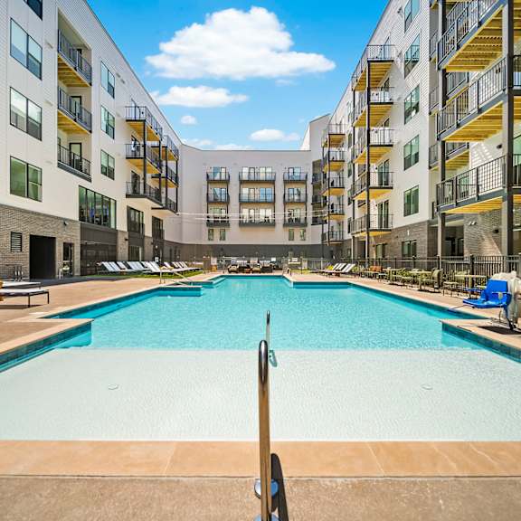 A large outdoor pool surrounded by apartment buildings.