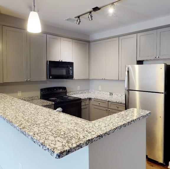 a kitchen with granite counter top and stainless steel refrigerator at Midtown Row, Alabama, 36106